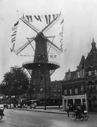 1984-386 Molen De Noord met de wieken versierd op Koninginnedag, op het Oostplein, gezien vanaf de Goudsesingel.