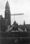 1985-319 Een luchtschip zweeft boven de binnenstad. Links de Koninginnekerk. Op de achtergrond het Wittte Huis.
