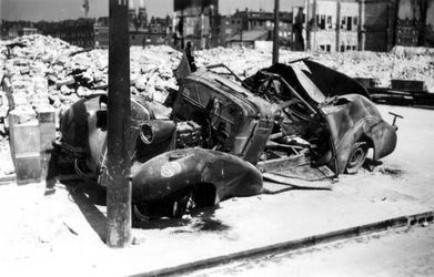 1985-526 Gezicht op de door het Duitse bombardement van 14 mei 1940 getroffen Plantageweg, met een autowrak. Op de ...