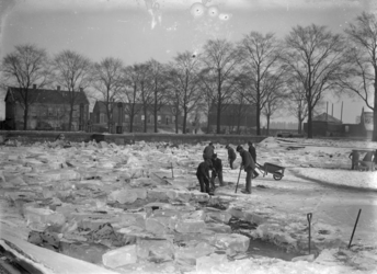 1986-2558 Werkers van de Gemeentelijke drinkwaterleiding aan het graven in de wintertijd aan de Honingerdijk.