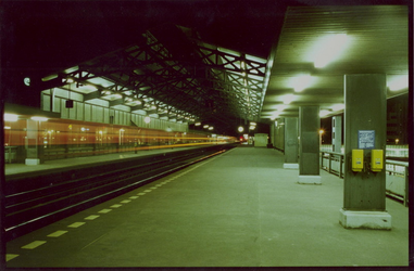 1988-1958 Avondopname van Station Blaak.Perrons met voorbijrijdende trein.