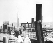 1991-854 Beurtvaartschip liggend aan de Boompjes.Op de achtergrond de spoorbrug en de Willemsbrug over de Nieuwe Maas.