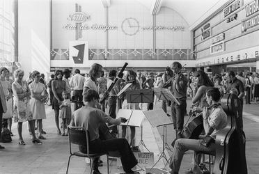 1993-6284 Het Sociaal Muziek Ensemble speelt in de vertrekhal van het Centraal Station.