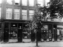 1994-382 Winkels aan de Aert van Nesstraat met rechts kruidenierswinkel In de Molen.