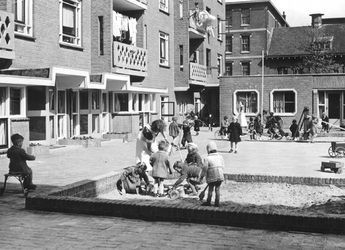 2004-5646 Kinderen en begeleiders op de speelplaats van een kinderbewaarplaats aan de Vredenoordlaan.
