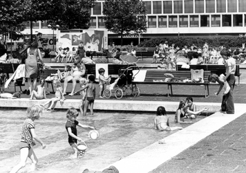 2005-7323 Kinderen spelen in een van de vijvers op het Schouwburgplein. Op de achtergrond De Doelen.