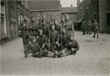 FD-12168 Een groep Nederlandse militairen op een binnenplaats.
