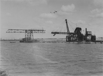 VII-371-01-01-3 Werkzaamheden tijdens de aanleg van de Merwehaen. De transporteur Waalhaven (rechts) vult de caissons ...