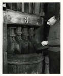 1968-1735 Tabaksverwerker. Fabricage van snuiftabak: het hakken van de tabak in de molen van de werkplaats van de firma ...