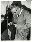 1969-1287 J. Hoogland, hersteller van gaten in kleding en tapijten aan het werk.