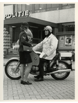 1973-1780 Motoragent op een BMW in gesprek met een agente voor het politiebureau.