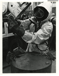 1974-908 Het beveiligingen van lekkende vaten met giftige stoffen met overmaatse drukvaten door een man met gasmasker ...