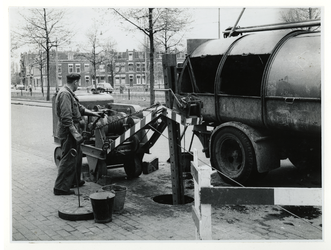 1975-326 Het reinigen van putten door de ROTEB (Reiniging, Ontsmetting, Transport en Brandweer) met behulp van doortreklier.