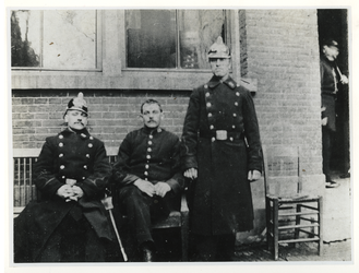 1975-428a Drie agenten van politie voor een politiepost.