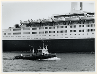 1977-1445 Een boot van de Havendienst (nummer 14) vaart mee met het grote Engelse passagiersschip Queen Elizabeth II .