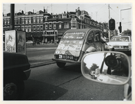 1977-2176 Beschilderde en beplakte auto, een 2CV4 of lelijke eend , in het stadsverkeer op de 's-Gravendijkwal op de ...