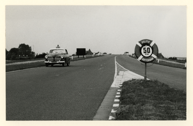1977-727 Een verkeersbord en Volvo Amazon van de Rotterdamse Politie met de aanbevolen snelheid 50 km/h.