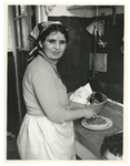1980-544 Marokkaanse berbervrouw maakt eten klaar voor het offerfeest. Ze heeft tatoeages op het gezicht en in de nek.