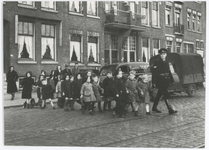 1998-4 Een politieagent begeleidt kinderen bij het oversteken.