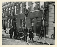 XXXIV-13-2 De Rotterdamsche Vrijwillige Brandweer in actie met een handblusspuit in de Volmarijnstraat.