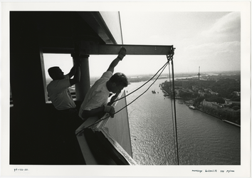 1996-2303 De montage van een tijdelijke buitenlift aan de top van de pyloon van de Erasmusbrug in aanbouw. Op de ...