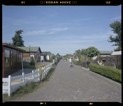 2005-2315-274 Een straat door het Recreatieoord Hoek van Holland. Links en rechts zijn tuinjes en vakantiewoningen te zien.