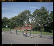 2005-2315-277 Een meisje op een kinderfiets voor de toegangsbrug naar het Recreatieoord Hoek van Holland.