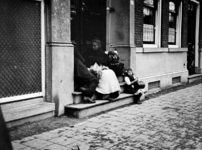 XXXIV-34-2 Gezicht op straatventers in een portiek van een huis aan de Mauritsweg.
