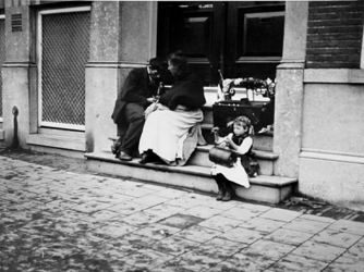 XXXIV-34-3 Gezicht op straatventers in een portiek van een huis aan de Mauritsweg.