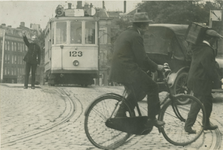 1969-1600 Een verkeersagent regelt het verkeer op het Hofplein.Op de achtergrond de Stationsweg.