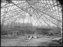 1976-11165 Persoonsdam met op de voorgrond een buisconstructie op het terrein waarop bouwaktiviteiten nabij de ...