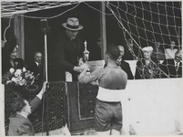 1976-14253 De koning van Noorwegen (Olav V) reikt een beker uit aan de aanvoerder van een voetbalelftal op het veld van ...