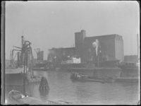 1976-4572 Op de voorgrond de Maashaven met overslag via graanelevatoren en schepen. Op de achtergrond de Maassilo.