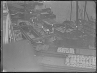 1976-4591 Het verladen van zakken aardappelen. Bovenaanzicht van binnenvaartschepen met lading in het ruim.