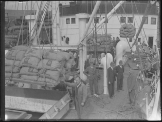 1976-4592 Verladen van balen uit het ruim van een schip. Het laden of lossen van zakken aardappelen.