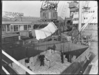 1976-5033 Laden en lossen vanuit het dek van een schip in de Lekhaven. Goederentreinwagons en kranen aan de kade.