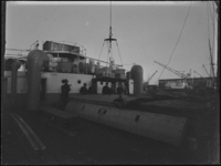 1976-5042 Laden en lossen van houten kisten uit de dekruimte van een schip aan de kade.
