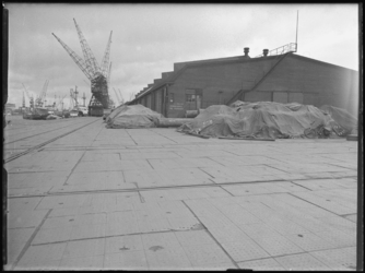 1976-5701 Het oostelijk havendeel van de Merwehaven. Goederen onder zeilen van de firma Bingham & co.