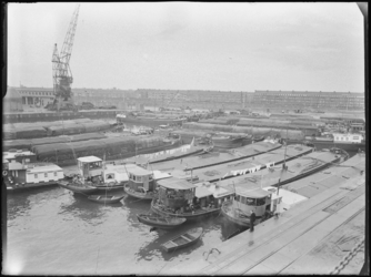 1976-6157 Overzicht van de Merwehaven, op de voorgrond binnenvaartschepen met Binghamzeilen afgedekte lading.