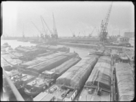 1976-6158 Overzicht van de Merwehaven, op de voorgrond binnenvaartschepen met Binghamzeilen afgedekte lading.