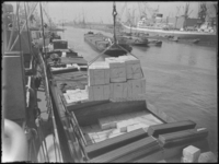 1976-6326 Laden en lossen. De overslag van stukgoederen in de Merwehaven vanuit een schip naar een binnenvaartschip.