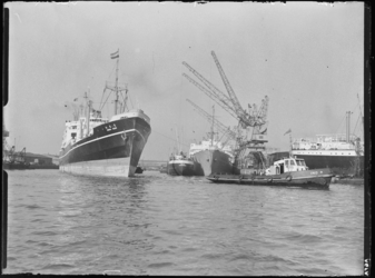 1976-7021 De toegang tot de Merwehaven. Op de voorgrond sleept een sleepboot het zeeschip Arima Maru.