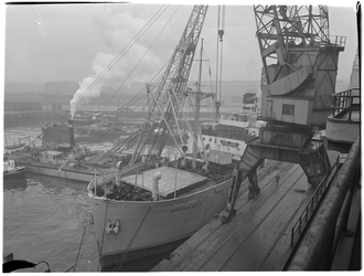 1976-7776 Het laden / lossen van zware stukken uit een schip met hulp van een drijvende bok in de Merwehaven.