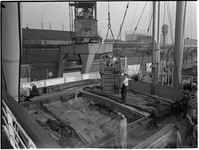 1976-7821 Paardentransport. In de haven hangt een paard in een houten kist waarmee hij op een schip zal worden gehesen.