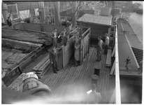 1976-7822 Paardentransport. In de haven is een paard met behulp van een houten transportkist op het dek van een schip ...