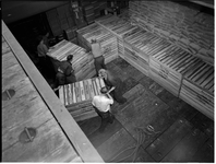 1976-7834 Het laden of lossen van kisten in of uit het ruim van een schip.