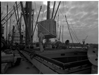 1976-7835 Het laden of lossen van kisten in of uit het ruim van een schip.