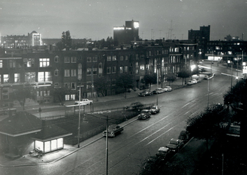 1976-8778 Gezicht op de Mathenesserlaan met op de achtergrond het Mathenesserplein, bij avond.