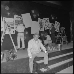 10228 Artiest Tom Manders zit 'in burger' op het toneel van zijn nieuwe theater 'Dorus'; op de achtergrond medewerkers ...