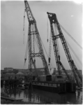 1045 Twee drijvende bokken van NV De Wit's bergings- en transportonderneming zetten een baggermolen te water in de Waalhaven.